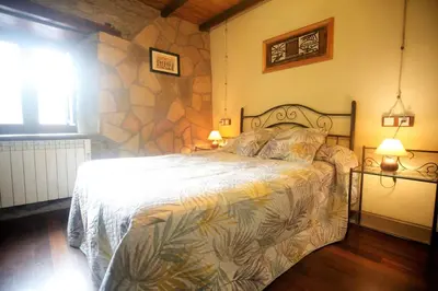 a bedroom with a large bed with a stone wall at Vivienda Vacacional Bioxana in Molejón