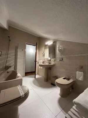 a bathroom with a toilet and a tub and a sink at Hotel Regueiro in Tox