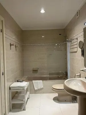 a bathroom with a tub and a toilet and a sink at Hotel Regueiro in Tox