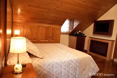 a bedroom with a bed and a table with a lamp at Hotel Restaurante La Casilla in Cangas del Narcea
