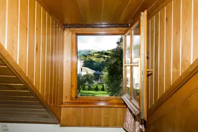 a window in a house with a view of a yard at Hotel Restaurante La Casilla in Cangas del Narcea