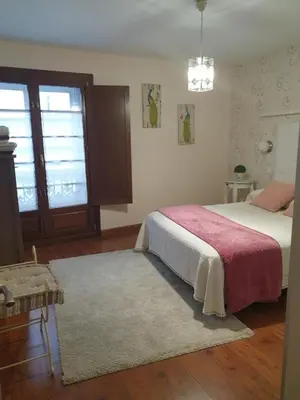 a bedroom with a bed with a red blanket and a rug at Apartamento Cine Colón in Ribadeo