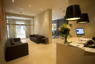 a living room with a couch and a table with flowers at Carris Cardenal Quevedo in Ourense