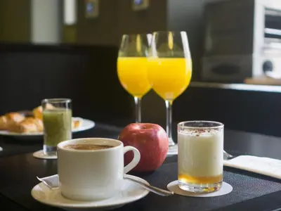 a table with two glasses of orange juice and an apple at Carris Cardenal Quevedo in Ourense
