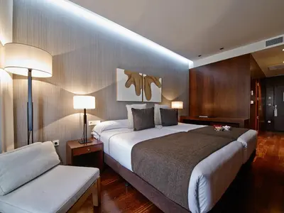 a hotel room with a large bed and a couch at Carris Cardenal Quevedo in Ourense