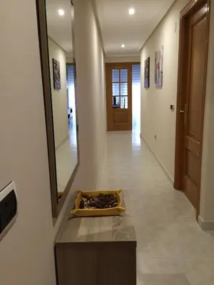 a hallway with a table and a mirror and a door at Tres dormitorios con magníficas vistas al mar in Foz