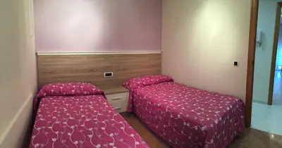 a small bedroom with a bed and a mirror at Tres dormitorios con magníficas vistas al mar in Foz