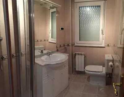 a bathroom with a sink and a toilet and a window at Tres dormitorios con magníficas vistas al mar in Foz