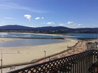 a view of a beach with a bridge and water at Tres dormitorios con magníficas vistas al mar in Foz
