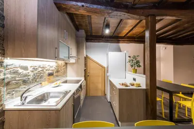 a kitchen with a sink and a refrigerator at Albergue O Candil in Melide