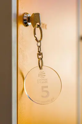 a key chain attached to a door with the number five at Albergue O Candil in Melide
