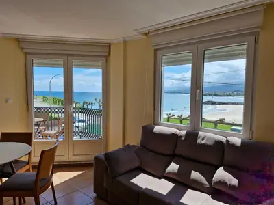 a living room with a couch and a view of the ocean at Apartamento Foz Playa in Foz