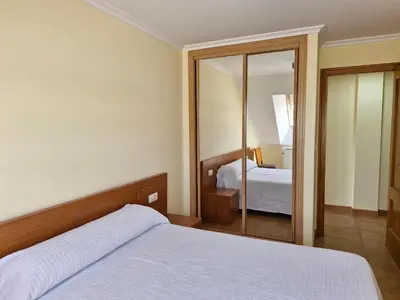 a bedroom with a bed and a mirror at Apartamento Foz Playa in Foz