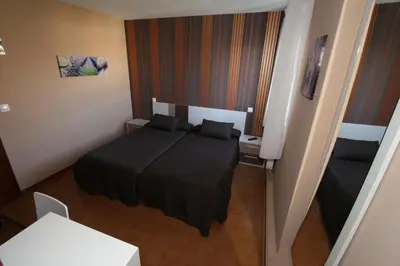 a small bedroom with a black bed and a desk at PR Plaza de Galicia in Santiago de Compostela