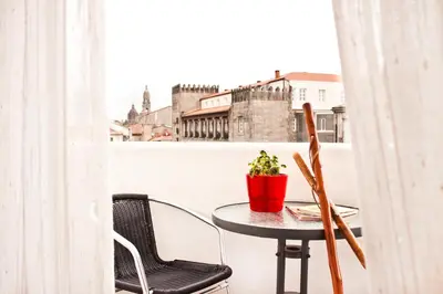 a table with a potted plant on a balcony at PR Plaza de Galicia in Santiago de Compostela