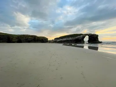 a beach with a rock formation in the water at Alojamientos Barreiros 3000 in Barreiros