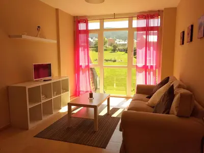 a living room with a couch and a table and a window at Alojamientos Barreiros 3000 in Barreiros