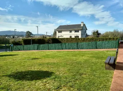 a bench in a yard with a fence and a house at Alojamientos Barreiros 3000 in Barreiros