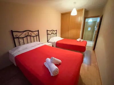 two beds in a hotel room with towels on them at Alojamientos Barreiros 3000 in Barreiros
