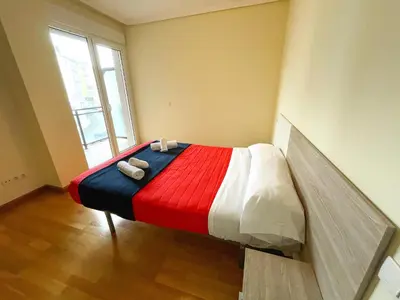 a bed in a room with a red white and blue blanket at Alojamientos Foz 3000 in Foz
