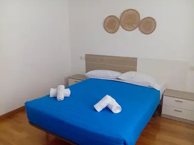 a bedroom with a blue bed with towels on it at Alojamientos Foz 3000 in Foz