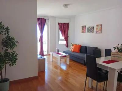 a living room with a blue couch and a table at Alojamientos Foz 3000 in Foz
