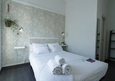 a bedroom with a white bed with towels on it at Hostal Mafer in Santiago de Compostela