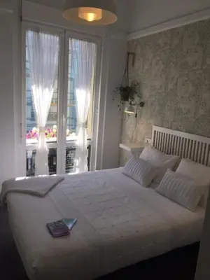 a bedroom with a large white bed with a window at Hostal Mafer in Santiago de Compostela
