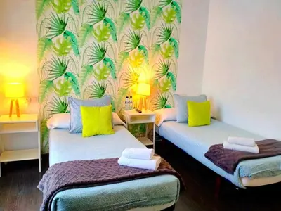 a room with two beds with yellow and blue at Hostal Mafer in Santiago de Compostela