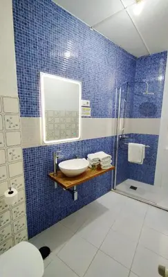 a blue tiled bathroom with a sink and a shower at Hostal Mafer in Santiago de Compostela