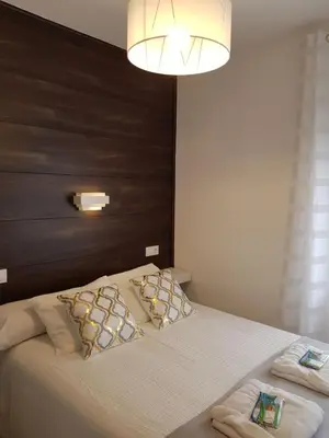 a bedroom with a large bed with a large headboard at Casa de Campo Cruz de Pedra in Portomarin
