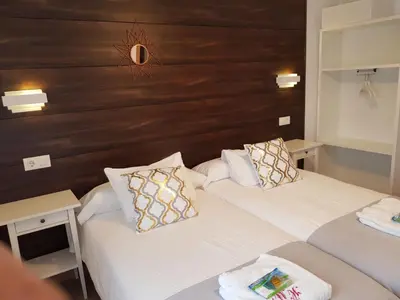 a hotel room with two beds and a wooden headboard at Casa de Campo Cruz de Pedra in Portomarin