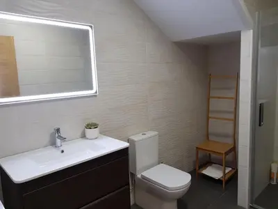 a bathroom with a toilet and a sink and a mirror at Casa de Campo Cruz de Pedra in Portomarin