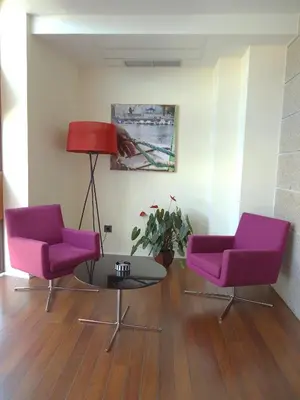 two purple chairs and a table in a room at Isla Nova Hotel in Foz