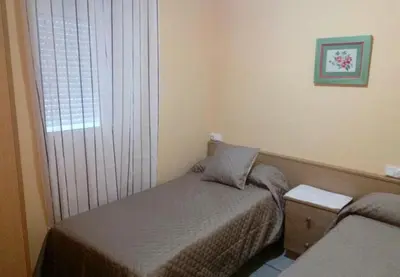 a small bedroom with a bed and a window at Hospedaje Mendez in Lugo