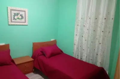 a bedroom with two beds with purple sheets at Hospedaje Mendez in Lugo