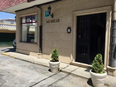 two potted plants sitting in front of a store at As Areas I in Viveiro