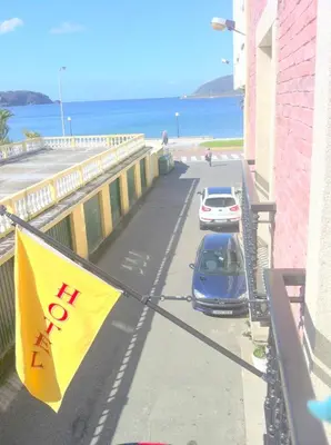 a car parked on a street next to the beach at As Areas I in Viveiro