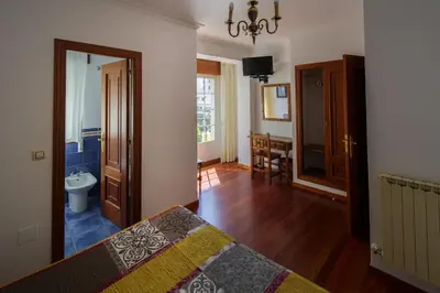 a bedroom with a bed and a bathroom with a sink at As Areas I in Viveiro
