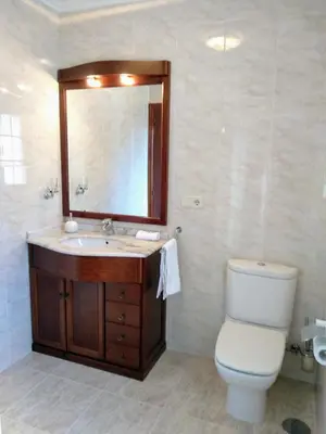 a bathroom with a sink and a toilet and a mirror at Villa Dorneda in Oleiros