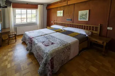 a bedroom with a bed and a table and a window at As Areas II in Viveiro