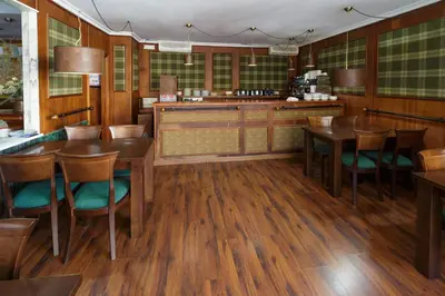 a dining room with wooden floors and wooden tables and chairs at As Areas II in Viveiro