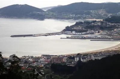 a view of a beach with a barge in the water at As Areas II in Viveiro