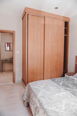 a bedroom with a large wooden cabinet and a bed at Piso centro in Ourense