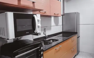 a small kitchen with a microwave and a sink at Piso centro in Ourense