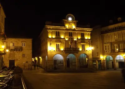an old building with a clock tower at night at Piso centro in Ourense