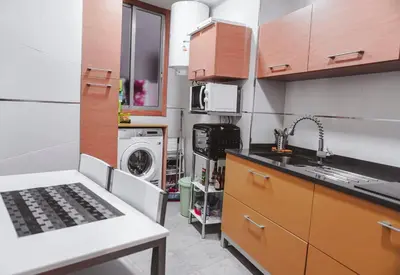 a kitchen with a sink and a washing machine at Piso centro in Ourense