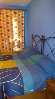 a bedroom with a bed with a blue wall at Apartamentos La Panerona in Tineo