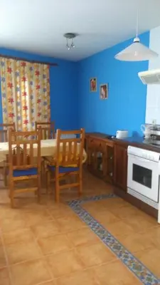 a kitchen with a table and chairs and blue walls at Apartamentos La Panerona in Tineo