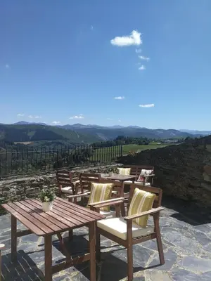 a group of wooden tables and chairs on a patio at Apartamentos La Panerona in Tineo